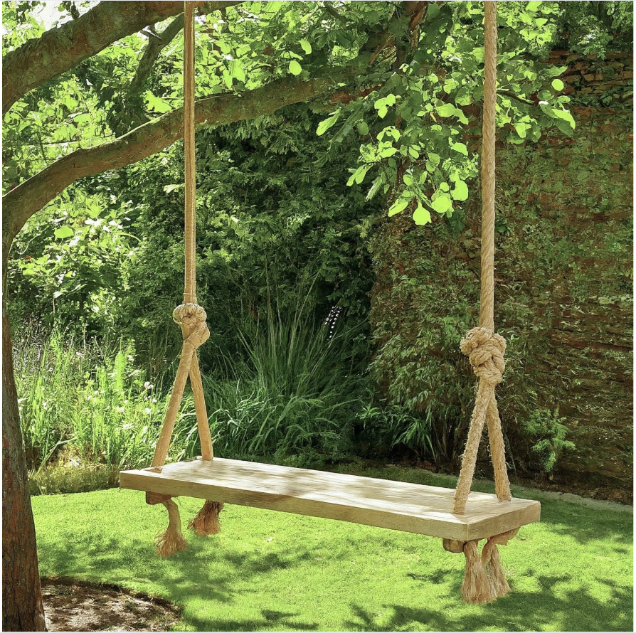 Huśtawka z deski zawieszona na linach jutowych w ogrodzie